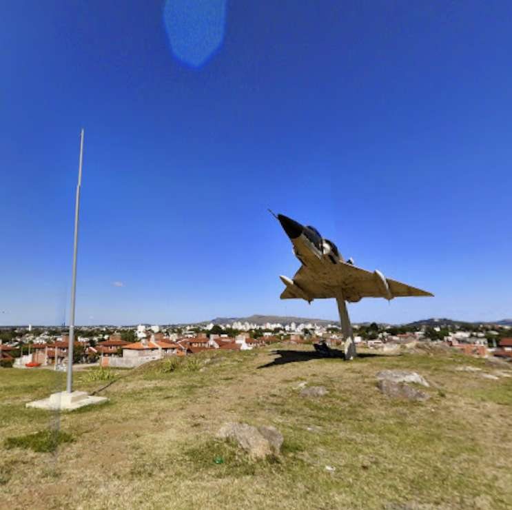 Avión Mirage exhibido en un espacio verde del barrio