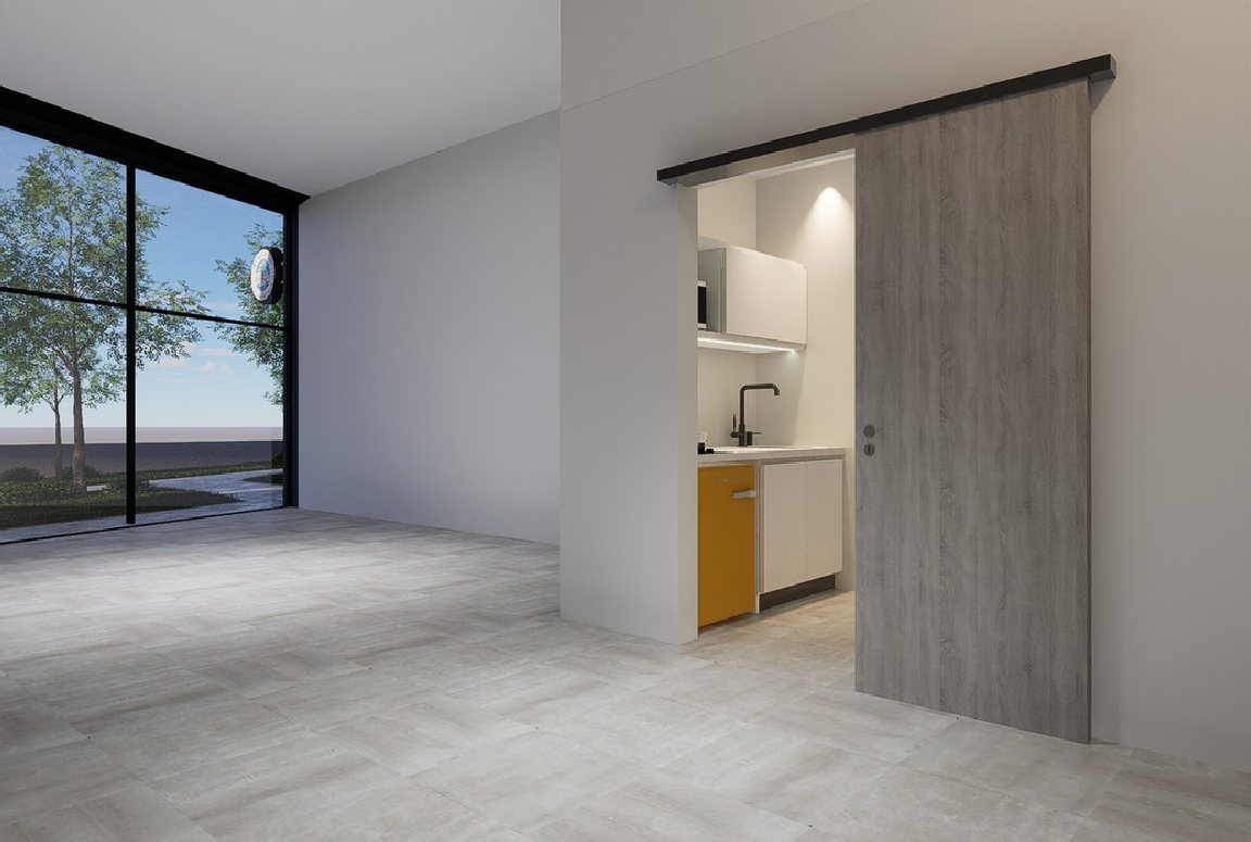 Interior de un local con gran ventanal y kitchenet